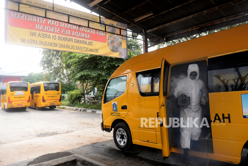Petugas melakukan dekontaminasi dan sterilisasi pada armada bus sekolah di Pool Unit Pengelola Angkutan Sekolah (UPAS) DKI Jakarta. Sebanyak 14 armada bus sekolah saat ini disiagakan sebagai alat transportasi warga yang tidak mengantongi Surat Izin Keluar Masuk (SIKM) dan akan masuk ke ibu kota Jakarta. (ilustrasi)
