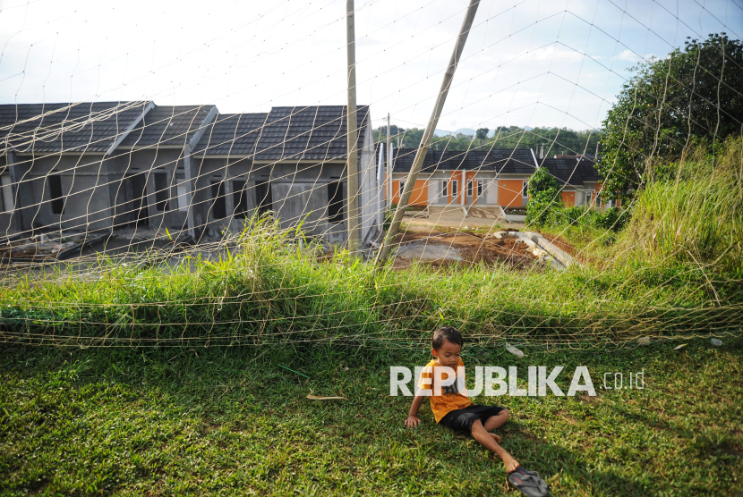 Seorang anak bermain dengan latar belakang pembangunan rumah subsidi di Perumahan Graha Arraya, Cibungbulang, Kabupaten Bogor, Jumat (21/2/2025) Bank Tabungan Negara (BTN) berkomitmen mendukung program 3 juta rumah dengan menyalurkan dan menyediakan akses Kredit Kepemilikan Rumah (KPR) subsidi untuk masyarakat berpenghasilan rendah dan pekerja informal. Selain itu BTN juga menerapkan berbagai strategi dan inovasi untuk mewujudkan program tersebut. Program 3 juta rumah ini diharapkan dapat menjadi momentum bangkitnya ekonomi nasional karena dapat mendorong pertumbuhan sektor perumahan dan berbagai industri terkait. Program 3 juta rumah bertujuan untuk meningkatkan kesejahteraan masyarakat Indonesia.