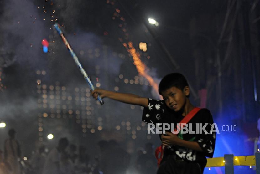 Anak-anak menyalakan petasan saat malam takbiran di Jalan tambak, Manggarai, Jakarta, Kamis (14/6).
