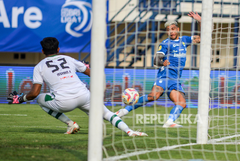 Pesepak bola Persib Bandung Ciro Alves (kiri) berusaha melewati penjaga gawang Persebaya Surabaya Andhika Ramadhani (kiri) pada pertandingan BRI Liga 1 di Stadion Si Jalak Harupat, Kabupaten Bandung, Jawa Barat, Jumat (18/10/2024). Pertandingan tersebut Persib Bandung menang dengak skor 2-0.  