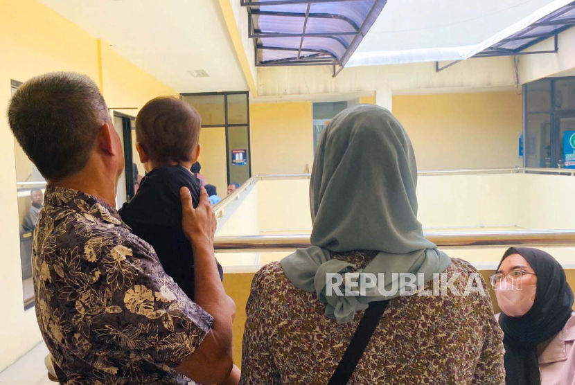 Pasangan suami istri Tabrani dan Siti Mauliah, menggendong anak kandungnya yakni GB (1) yang sempat tertukar di RS Sentosa Bogor tahun lalu. Saat ini dua keluarga bayi tertukar tengah menjalani proses bonding di Unit PPA Polres Bogor, Senin (4/9/2023). 