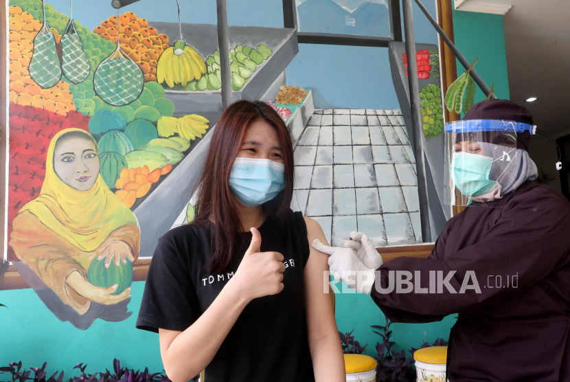 Seorang petugas kesehatan Indonesia memberikan dosis vaksin COVID-19 Sinovac kepada seorang wanita selama kampanye vaksinasi massal untuk vendor dan penjaga toko di Pasar Cisalak di Depok, Jawa Barat, Indonesia, 09 Maret 2021. Indonesia telah memulai tahap kedua nasional Upaya vaksinasi COVID-19 sebagai negara mencatat lebih dari satu juta kasus, jumlah tertinggi di Asia Tenggara.