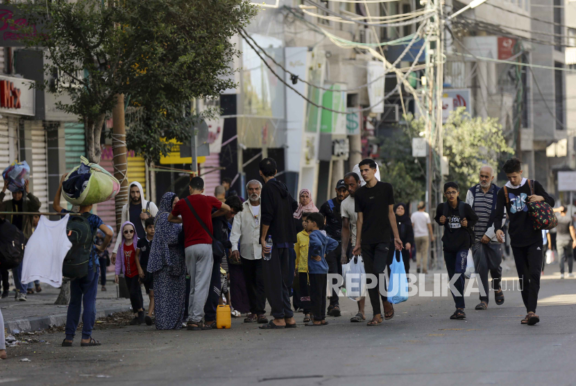 Warga Palestina berjalan di lingkungan al-Rimal, pusat Kota Gaza sambil melarikan diri ke Jalur Gaza selatan, Rabu, 8 November 2023.