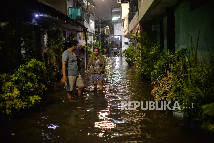 Warga berjalan melintasi area yang terendam banjir di kawasan Pela Mampang, Jakarta Selatan, Rabu (4/1/2023). Banjir tersebut mencapai ketinggian 60 centimeter akibat intensitas hujan yang lebat yang menyebabkan Kali Mampang meluap. Sementara, menurut data Badan Penanggulangan Bencana Daerah (BPBD) DKI Jakarta, banjir terjadi di 28 RT dan 3 ruas jalan di Ibu Kota dengan ketinggian maksimal sekitar 100 centimeter. Hujan Deras Guyur DKI Jakarta, 19 RT Banjir