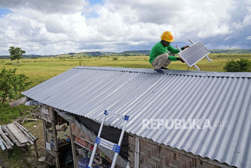 Antonius Makambombu, a worker of Sumba Sustainable Solutions performs maintenance work on a solar panel on the roof of a customer