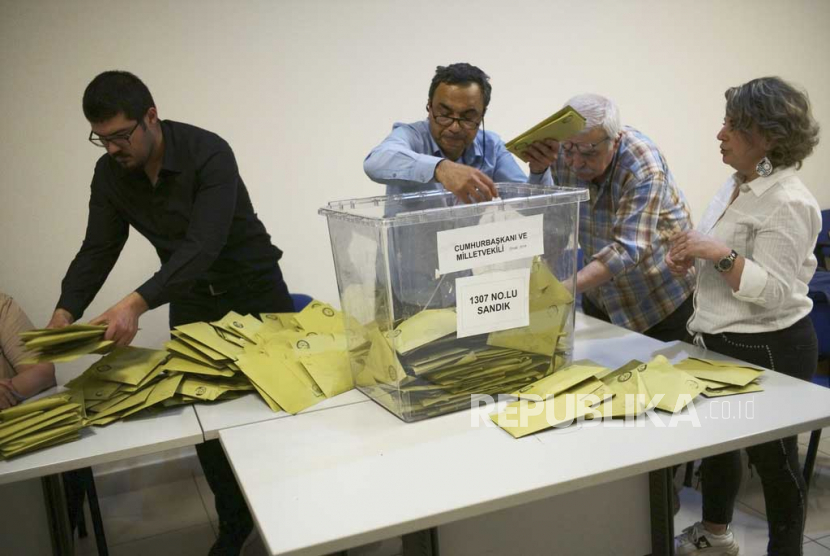 Petugas menghitung suara di tempat pemungutan suara, di Ankara, Turki,  Ahad, (14/5/2023).