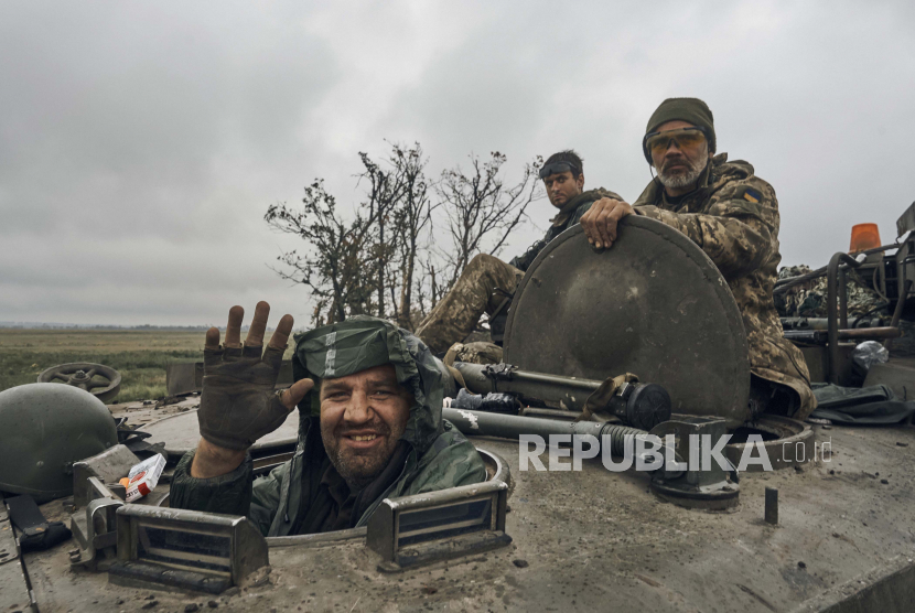 A Ukrainian soldier smiles from a military vehicle on the road in the freed territory in the Kharkiv region, Ukraine, Monday, Sept. 12, 2022. Ukrainian troops retook a wide swath of territory from Russia on Monday, pushing all the way back to the northeastern border in some places, and claimed to have captured many Russian soldiers as part of a lightning advance that forced Moscow to make a hasty retreat.