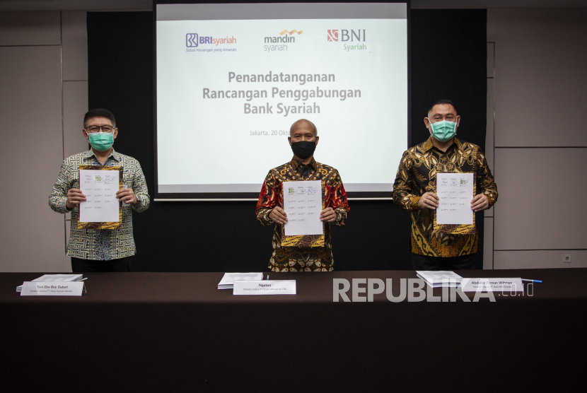 Direktur Utama PT Bank Syariah Mandiri Toni EB Subari (kiri) bersama Direktur Utama PT Bank BRIsyariah Tbk Ngatari (tengah) dan Direktur Utama PT Bank BNI Syariah Abdullah Firman Wibowo (kanan) menunjukkan berkas usai menandatangani Rancangan Penggabungan Bank Syariah di Jakarta, Selasa (20/10/2020). 