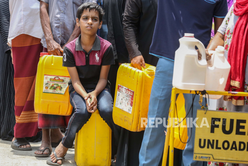  Orang-orang menunggu untuk membeli minyak tanah di sebuah pompa bensin di tengah kelangkaan bahan bakar di Kolombo, Sri Lanka, 21 Maret 2022. Negara kepulauan itu sangat terpukul oleh kekurangan devisa, yang mengakibatkan kelangkaan pangan, bahan bakar, dan barang-barang impor yang parah.