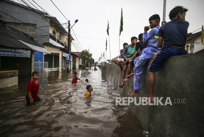 Sejumlah anak bermain saat terjadi banjir di Perumahan Pondok Maharta, Tangerang Selatan, Banten, Sabtu (6/1/2024). BMKG mengimbau masyarakat wilayah Banten mewaspadai hujan lebat.