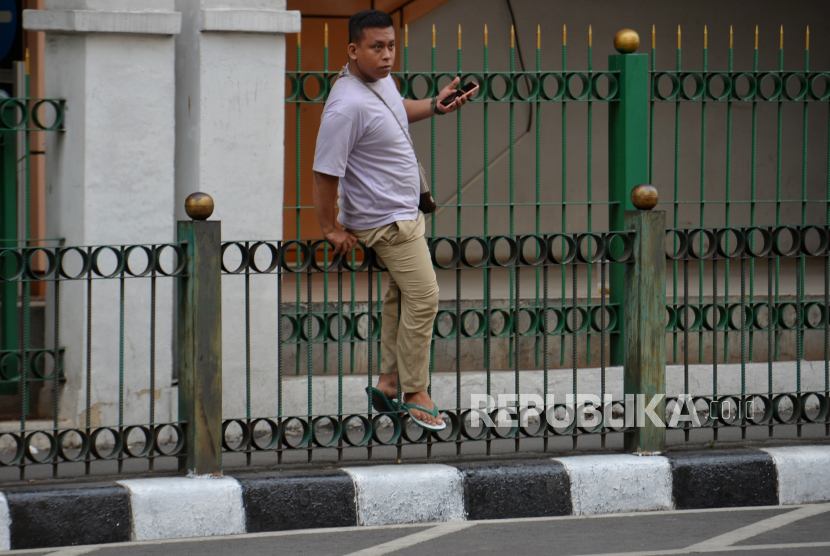 Warga melompati pagar pembatas trotoar di kawasan Stasiun Cikini, Jakarta, Selasa (31/10/2023). Meski terdapat spanduk larangan melompati pagar, sebagian warga tetap melakukan tindakan tersebut  sebagai jalan pintas untuk memangkas waktu tempuh menuju area stasiun Cikini.