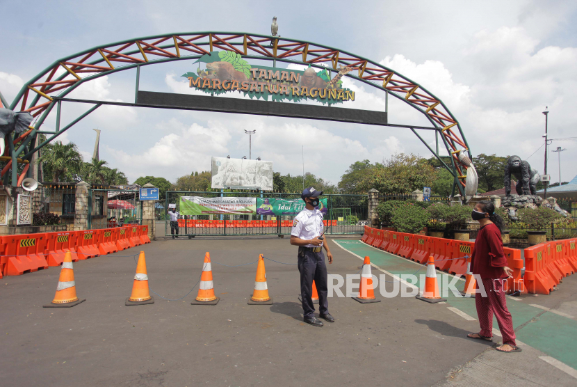 Petugas berjaga di pintu masuk Taman Margasatwa Ragunan, Jakarta, Ahad (31/5/2020). Presiden Joko Widodo menyatakan sektor pariwisata harus mempersiapkan diri menyambut tatanan normal baru dengan tetap produktif dan aman dari COVID-19