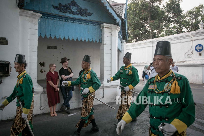 Dua wisatawam asing menyaksikan prajurit Keraton Kasunanan Surakarta berbaris mengikuti Atraksi Prajurit Keraton di Solo, Jawa Tengah, Sabtu (26/8/2023). 