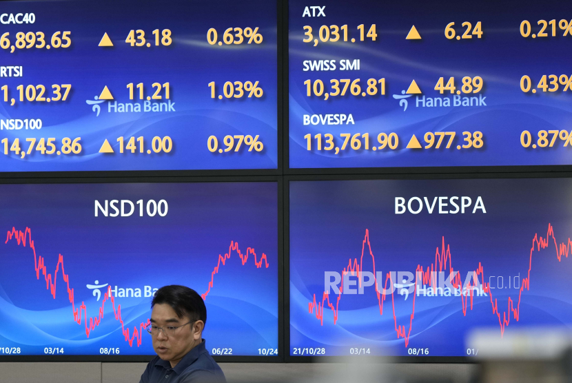 A currency trader walks by the screens at a foreign exchange dealing room in Seoul, South Korea, Wednesday, Oct. 25, 2023. Asian shares advanced Wednesday, tracking gains on Wall Street after Verizon and other big companies reported fatter profits for the summer than expected. 