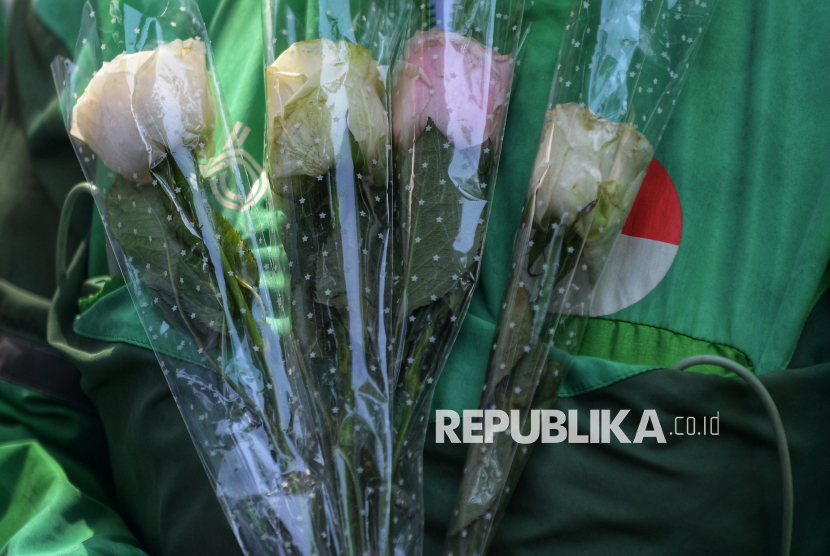 Sejumlah pengemudi ojek online (ojol) membawa bunga saat menggelar aksi damai ojol di Kawasan Monas, Jakarta, Selasa (2/9/2025). 
