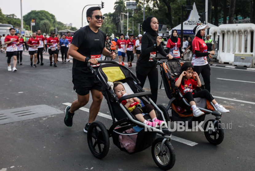 Peserta mendorong kereta bayi saat mengikuti BTN Jakarta Run 2023 di Jalan MH Thamrin, Jakarta, Ahad (12/11/2023). Ibu perlu berolahraga untuk menangkal stres dan kecemasan setelah melahirkan.