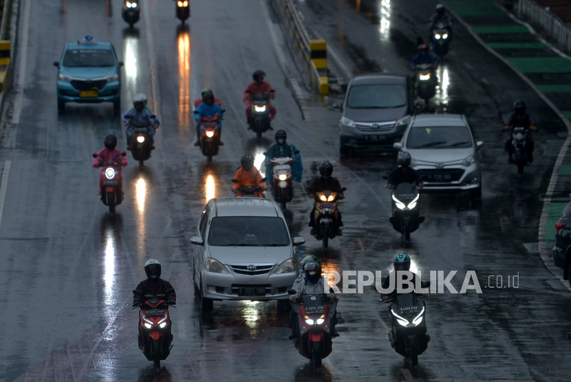 Warga dengan mengunakan payung menerjang hujan di kawasan Jalan  Gatot Subroto, Jakarta, Jumat (9/12/2022). 