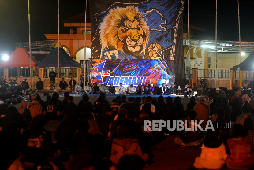 Aremania menghadiri malam dia bersama untuk peringatan setahun Tragedi Kanjuruhan di Stadion Kanjuruhan, Malang, Ahad (1/10/2023). 