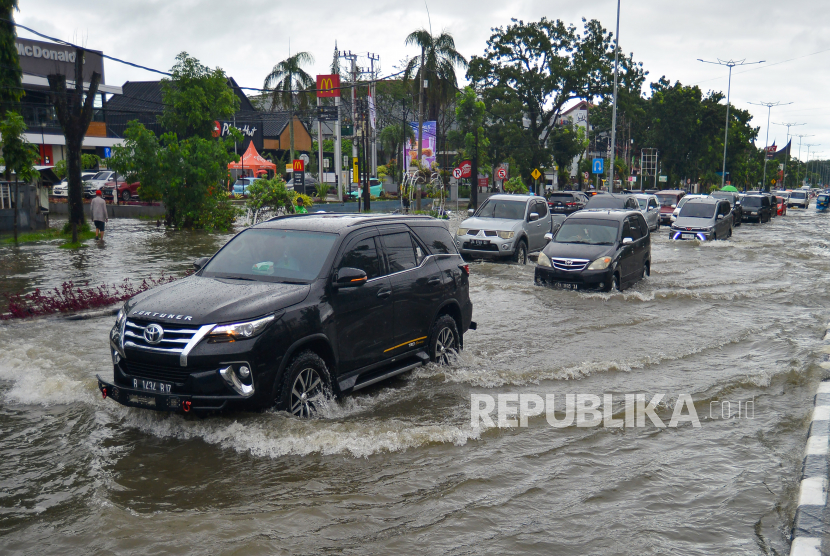 Sejumlah mobil melintasi banjir di jalan protokol Padang (ilustrasi).