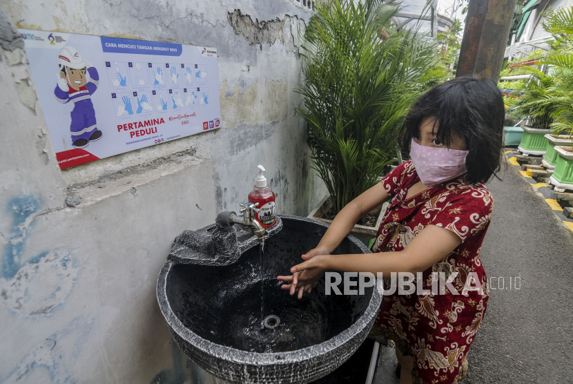 Seorang anak memakai masker saat mencuci tangan, (ilustrasi). Menteri Kesehatan Budi Gunadi Sadikin mengatakan mencuci tangan pakai sabun efektif mencegah penyakit menular di tengah pandemi Covid-19 dan cuaca ekstrem seperti saat ini.