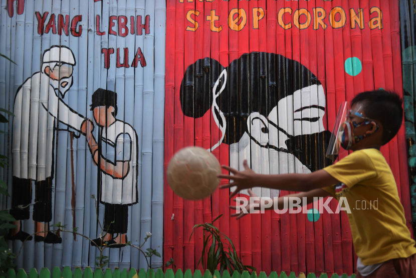 Seorang anak bermain di depan mural bertema COVID-19 di Jakarta, Senin (27/7/2020). Berdasarkan data dari Satgas Penanganan COVID-19 per 27 Juli 2020, kasus positif COVID-19 di Indonesia telah mencapai 100.303 kasus, dimana 58.173 orang dinyatakan sembuh dan 4.838 orang meninggal dunia.