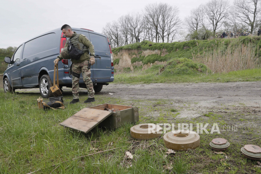  Seorang pencari ranjau Ukraina menyiapkan peralatan sebelum penghancuran ranjau anti-tank dan bahan peledak lainnya .