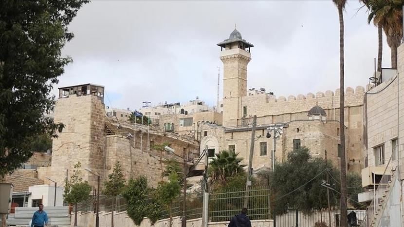 Pemukim Israel mengibarkan bendera nasional di atas Masjid Ibrahimi di kota Hebron, Tepi Barat, menjelang Hari Kemerdekaan Israel