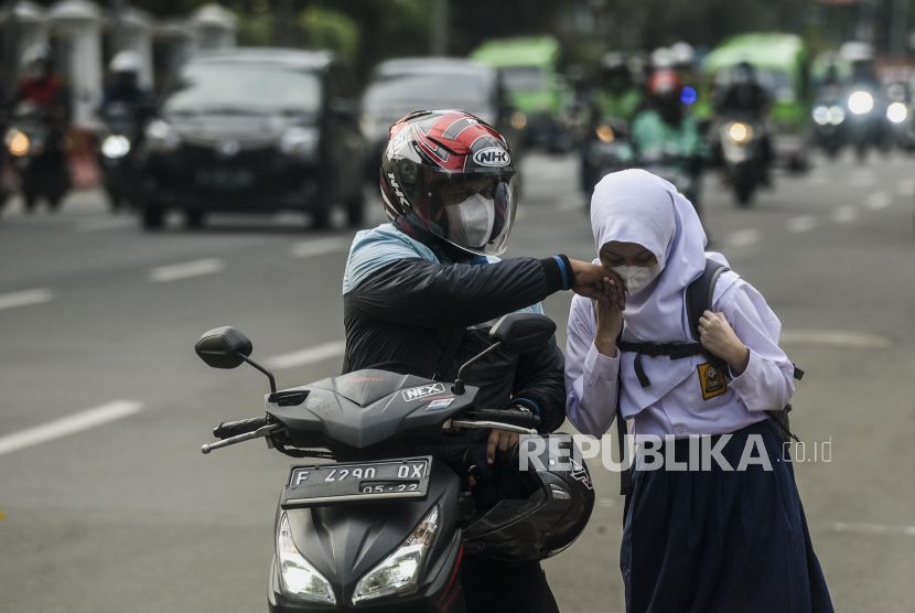 Pelajar salam kepada orang tuanya sebelum menghadiri Pembelajaran Tatap Muka (PTM) di Kota Bogor. PTM 100 persen di Kota Bogor saat ini dihentikan. (ilustrasi)