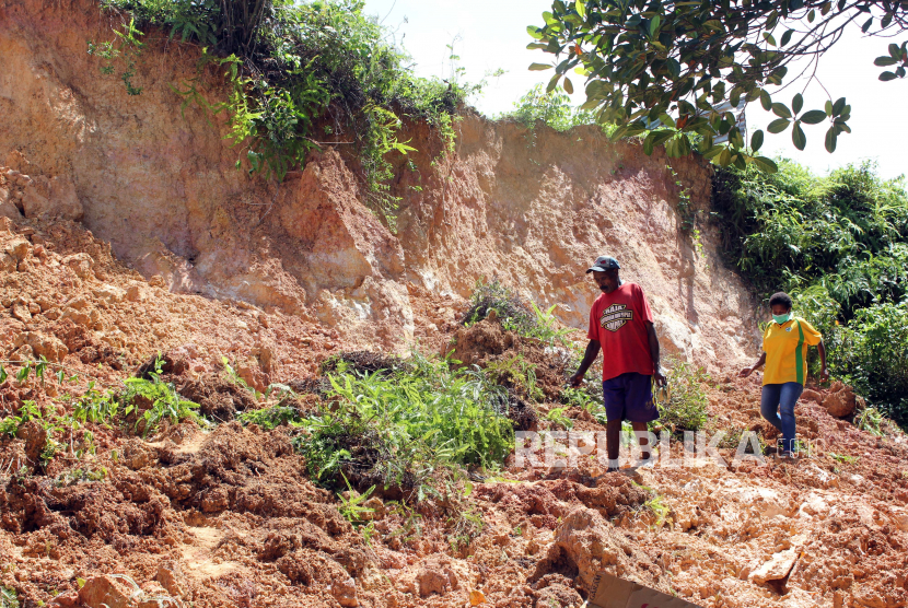Warga melintas di dekat lokasi tanah longsor di Sorong, Papua (ilustrasi)