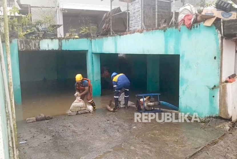 Petugas melakukan penanganan banjir yang menggenangi lingkungan sekitar Pondok Pesantren Miftahul Huda, Kecamatan Manonjaya, Kabupaten Tasikmalaya, Jawa Barat, Jumat (7/7/2023). 