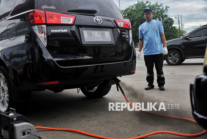 Petugas melakukan uji emisi kendaraan bermotor secara gratis di Jalan Perintis Kemerdekaan, Pulogadung, Jakarta, Selasa (3/12/2024). Dinas Lingkungan Hidup DKI Jakarta bekerja sama dengan Dinas Perhubungan dan Kepolisian menyelenggarakan kegiatan Pemantauan Kepatuhan Kewajiban Uji Emisi bagi pengendara untuk mensosialisasikaan tentang pentingnya menjaga kualitas udara dengan menggunakan kendaraan sesuai standar baku mutu emisi. Bagi pengendara yang tidak lolos uji emisi akan dikenai denda tilang berbasis ETLE, denda pajak tahunan serta tarif parkir tertinggi di beberapa lokasi tertentu.