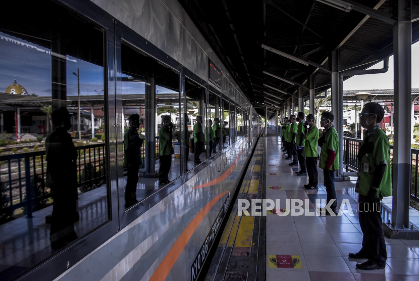 Petugas memberikan hormat kepada penumpang kereta api di Stasiun Bandung, Kota Bandung, Ahad (3/1/2021).