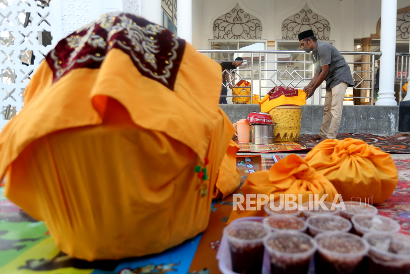 Warga membawa dan menata hidangan khas Aceh yang berisi makanan untuk berbuka puasa pada tradisi kenduri Nuzulul Quran di Masjid Al-Ikhlas, Desa Ilie, Banda Aceh, Aceh, Ahad (25/4/2021). Kenduri Nuzulul Quran yang telah menjadi tradisi di Provinsi Aceh dirayakan setiap tahun pada bulan Ramadhan dengan cara berbuka puasa bersama. 