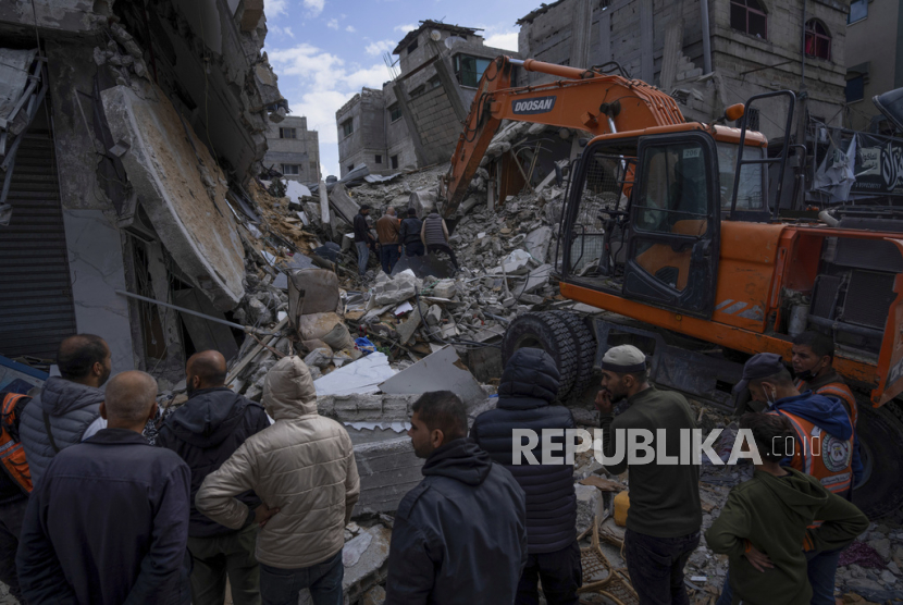 Warga Palestina mencari jenazah dan korban selamat di reruntuhan bangunan tempat tinggal yang hancur akibat serangan udara Israel di Rafah, Jalur Gaza, Senin (4/3/2024).