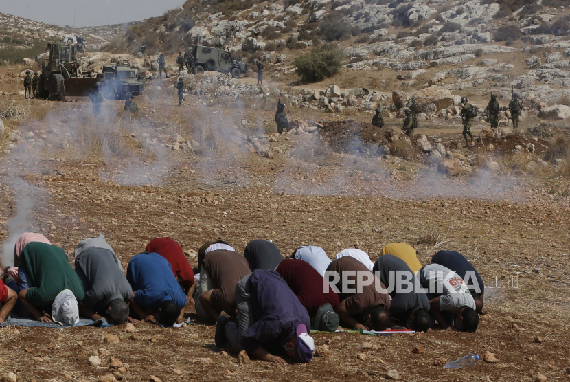  Tentara Israel menembakkan gas air mata ke arah warga Palestina selama sholat selama demonstrasi menentang permukiman Israel di desa Be Dajan dekat kota Nablus, Tepi Barat utara,  Jumat (9/10/2020). UEA Kecam Pembangunan Permukiman Baru Israel di Wilayah Palestina