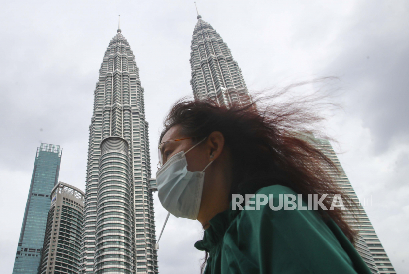 Seorang wanita yang memakai masker wajah berjalan di Menara Kembar Petronas di Kuala Lumpur, Malaysia. Malaysia menduduki peringkat ke-36 dari 132 negara berdasarkan Laporan Indeks Inovasi Global (GII) 2022. Ilustrasi.