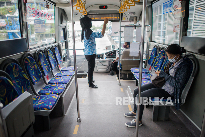 Penumpang  menerapkan jarak sosial saat menaiki bus Transjakarta di Halte Harmoni, Jakarta, Kamis (9/4). Pemerintah Provinsi DKI Jakarta akan membatasi jam operasional dan jumlah penumpang untuk semua jenis transportasi umum di wilyaha DKI Jakarta serta mewajibkan semua penumpang untuk menggunakan masker dan menerapkan jarak sosial pada saat penerapan pembatasan sosial berskala besar (PSBB)  10 April 2020 mendatang