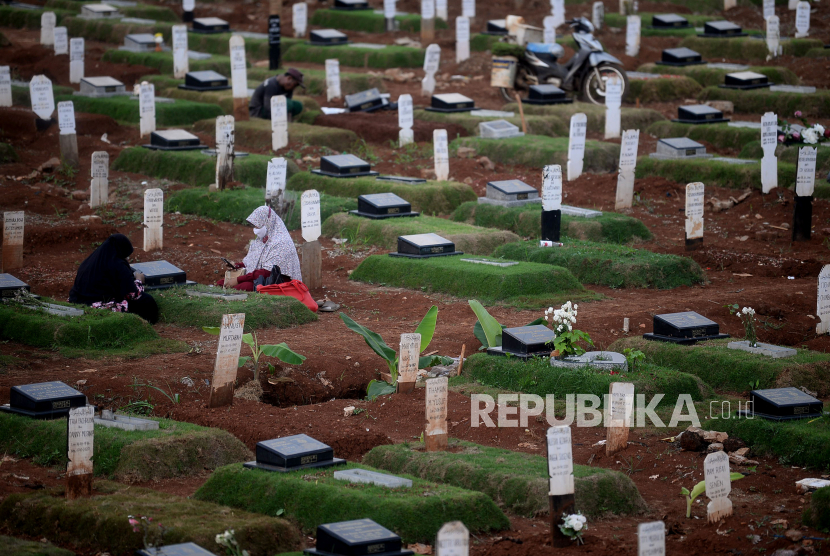 Keluarga berziarah di lokasi pemakaman jenazah dengan protokol Covid-19 di TPU Pondok Ranggon, Jakarta Timur, Kamis (26/11).