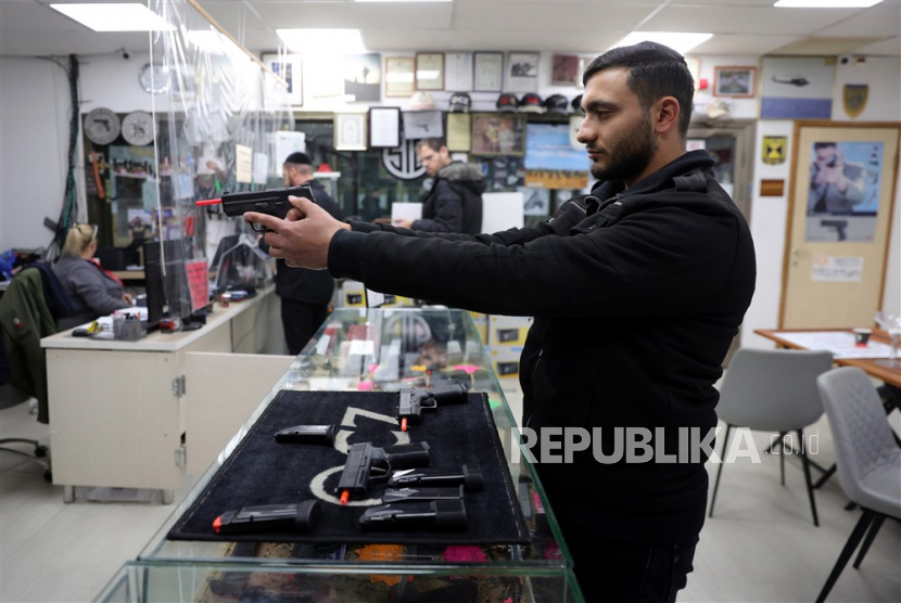  Seorang pria Israel memeriksa beberapa senjata di toko senjata di pemukiman Israel. Otoritas Israel tidak akan lagi menyita senjata para pemukim yang menembak warga Palestina