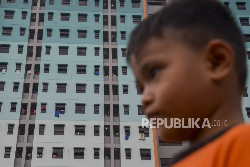 Di tengah tingginya kebutuhan rumah bagi masyarakat, justru banyak rumah dinas yang kosong. Foto ilustrasi seorang anak bermain dengan latar belakang jendela hunian sebuah rusunawa di Jakarta.