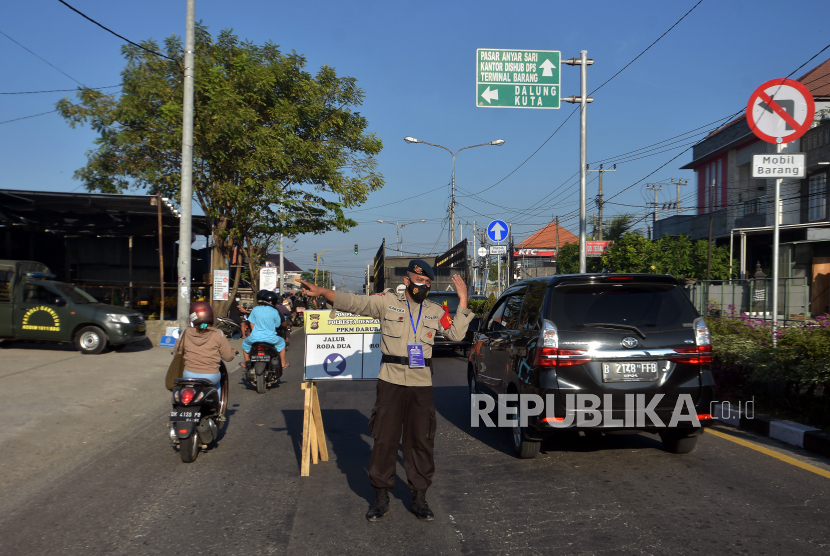 Anggota Polisi mengatur lalu lintas saat operasi penyekatan dalam pelaksanaan Pemberlakuan Pembatasan Kegiatan Masyarakat (PPKM) yang diperpanjang di Pos Uma Anyar, Denpasar, Bali, Rabu (21/7/2021). Gubernur Provinsi Bali mengeluarkan Surat Edaran Nomor 11 Tahun 2021 tentang Pemberlakuan Pembatasan Kegiatan Masyarakat (PPKM) Level 3 COVID-19 di Kabupaten/Kota se-Bali yang dimulai pada 21 - 25 Juli 2021 untuk menekan penyebaran COVID-19 di Pulau Bali yang masih meningkat. 