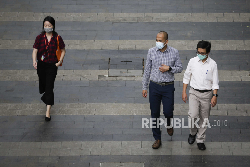 Orang-orang yang memakai masker pelindung wajah berjalan di trotoar kawasan bisnis di Jakarta. Berbagai upaya dilakukan pemerintah untuk memperbaiki ekonomi saat pandemi, anggaran dana Pemulihan Ekonomi Nasional (PEN) 2020 terserap 83.4 persen dari pagu Rp 695 triliun.