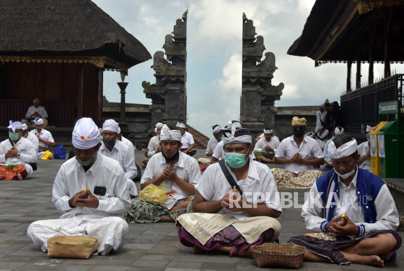 Umat Hindu melakukan persembahyangan dalam upacara Peneduh Gumi yang dipusatkan di Pura Besakih, Karangasem, Bali, Rabu (22/4/2020). Upacara yang digelar oleh Parisada Hindu Dharma Indonesia (PHDI) Provinsi Bali dan Majelis Desa Adat (MDA) Provinsi Bali tersebut dilaksanakan serentak di seluruh Desa Adat se-Bali untuk memohon agar semuanya segera terbebas dari pandemi COVID-19