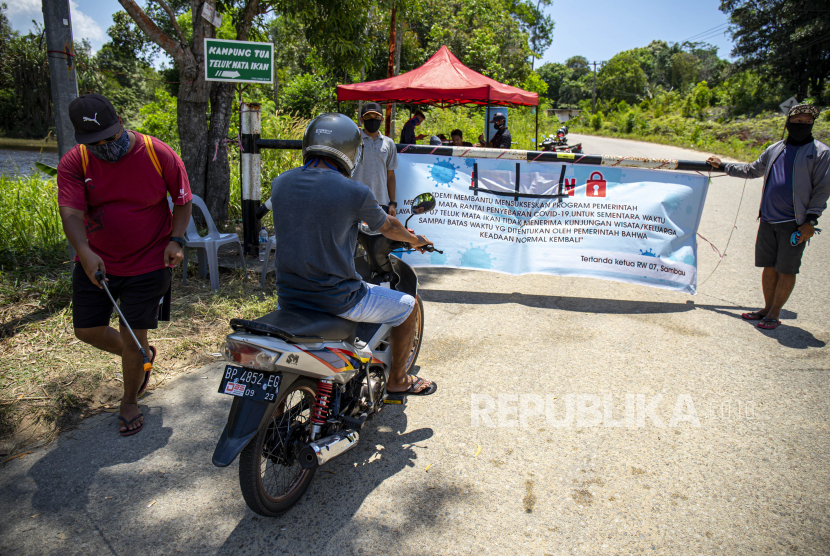 Warga menyemprotkan cairan disinfektan ke kendaraan yang digunakan warga pendatang yang akan memasuki wilayah Kampung Tua Teluk Mata Ikan, Batam, Kepulauan Riau, Rabu (15/4). (ilustrasi)
