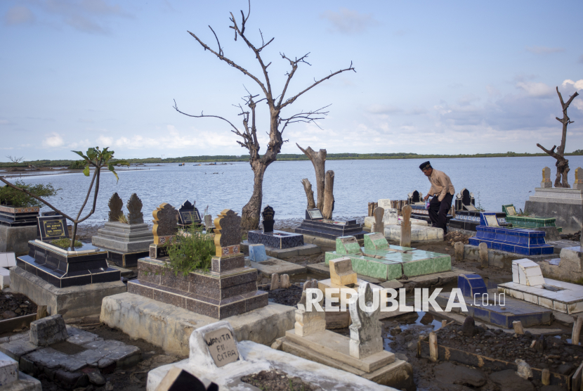 Warga berziarah ke makam keluarga yang terendam air rob di tempat pemakaman umum (TPU) Desa Eretan Kulon, Kandanghaur, Indramayu, Jawa Barat, Kamis (27/2/2025). Ziarah kubur atau nyekar jelang bulan Ramadhan itu  merupakan salah satu tradisi umat muslim setempat untuk mendoakan sanak saudara mereka yang telah meninggal dunia. 