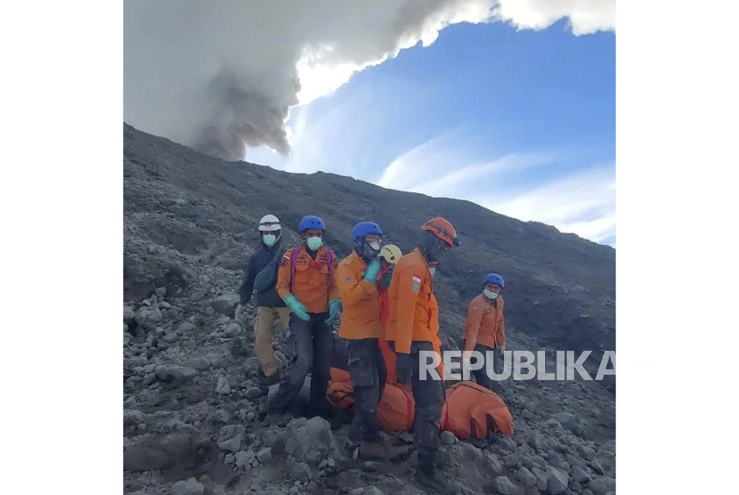 In this undated photo released Dec. 5, 2023, by the Indonesian National Search and Rescue Agency (BASARNAS), rescuers evacuate the body of a climber killed in Mount Marapi