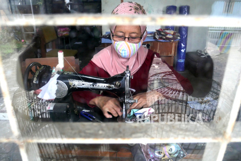 Hariah (72) mengerjakan pesanan masker dari kain batik lukis di Seno Batik, Mantrijeron, Yogyakarta, Senin (19/10). Pembuatan masker berbahan batik lukis ini memanfaatkan lesunya penjualan batik lukis imbas pandemi Covid-19. Penjualan pun menggunakan sistem daring, dan setiap masker dijual dengan harga Rp 20 ribu hingga Rp 30 ribu.