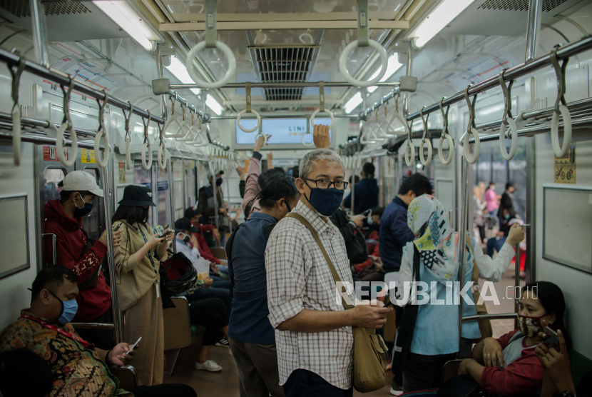 Penumpang menggunakan masker saat menaiki Kereta Rel Listrik di Stasiun Tanah Abang, Jakarta, Kamis (11/6). 