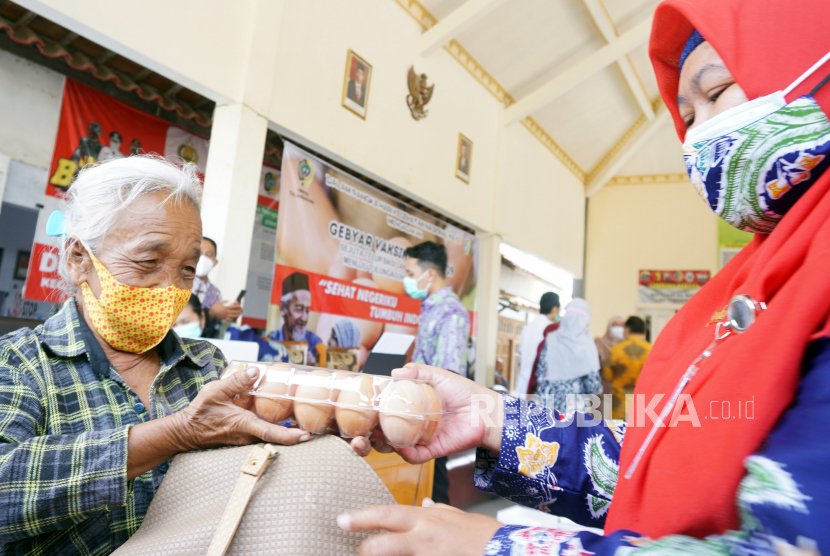 Petugas menyerahkan hadiah telur kepada warga lansia usai vaksinasi dosis pertama di Tulungagung, Jawa Timur, Selasa (19/10/2021). Untuk mempercepat capaian 40 persen dari total sasaran 130 ribu lansia daerah itu sebagai prasayarat perubahan status PPKM level 3 ke level 2, pemerintah daerah setempat memberi stimulan hadiah 10 butir telur bagi warga usia lanjut yang sukarela menjalani vaksinasi COVID-19. 