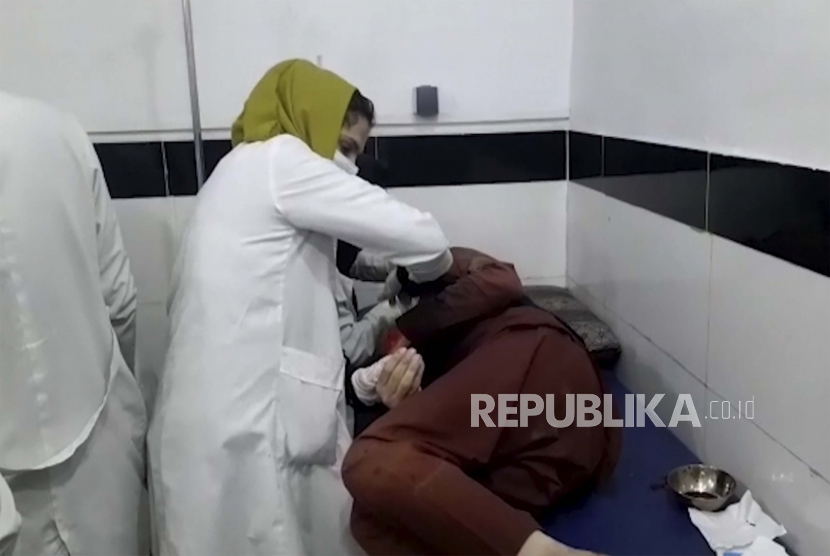 Dalam bingkai yang diambil dari video ini, seorang pekerja medis merawat seseorang yang terluka dalam ledakan mematikan di bandara Kabul, di sebuah rumah sakit di Kabul, Afghanistan, Kamis, 26 Agustus 2021. 
